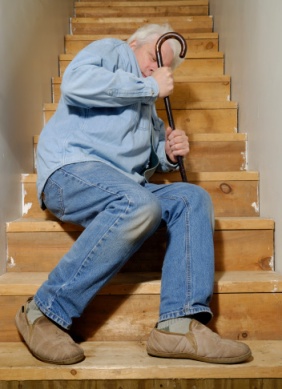 Imagen de un anciano caído sobre unas escaleras